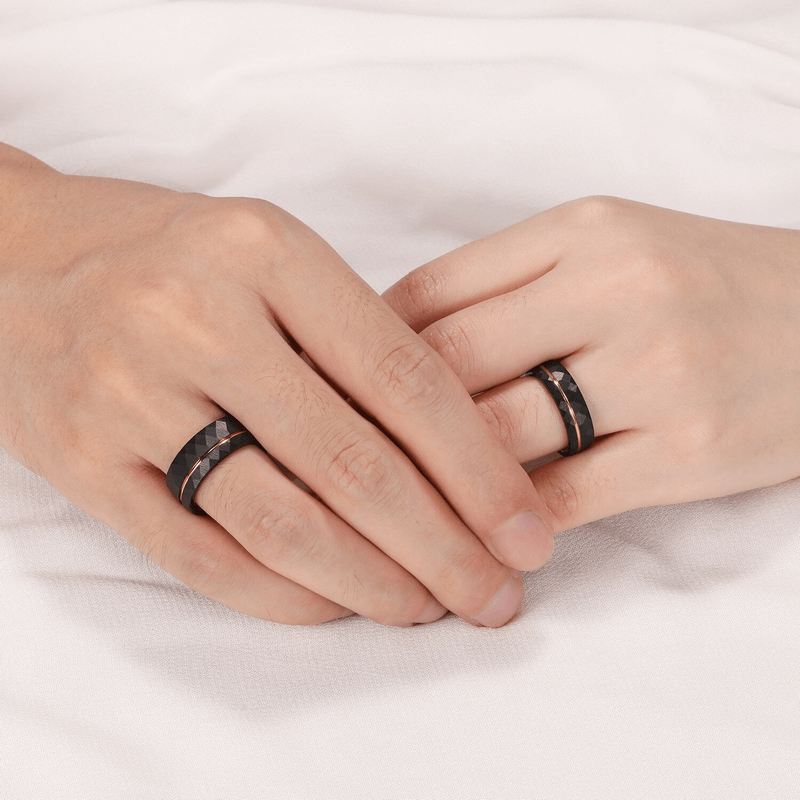 Two hands wearing unisex rhombus patterned tungsten steel rings on a soft background.