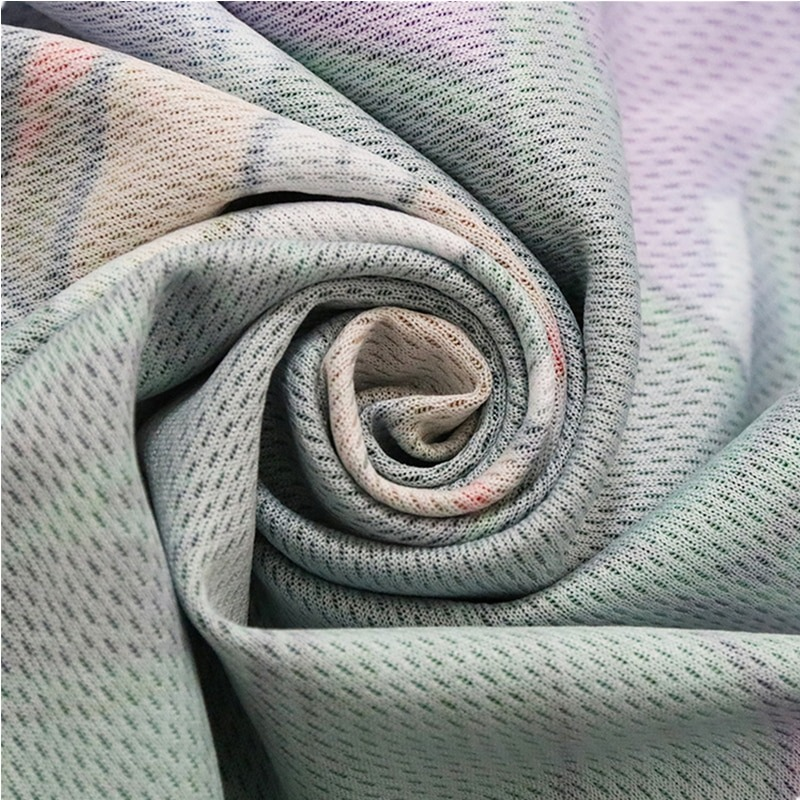 Close-up of soft, patterned fabric rolled in a spiral, showcasing its lightweight and breathable texture.
