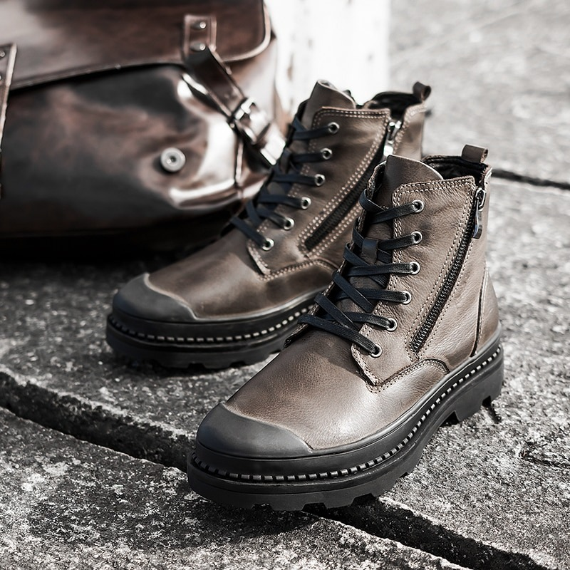 Stylish rock style men's leather ankle boots with laces and sturdy sole, paired with a classic brown bag.