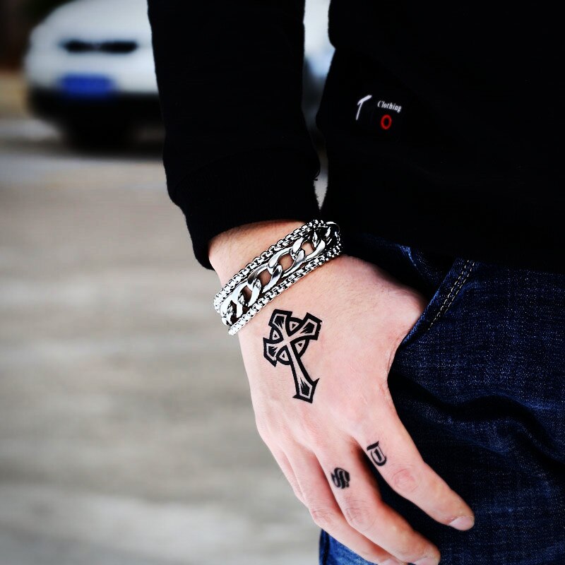 Rock style chain wide bracelet worn on tattooed wrist, showcasing trendy stainless steel fashion jewelry.