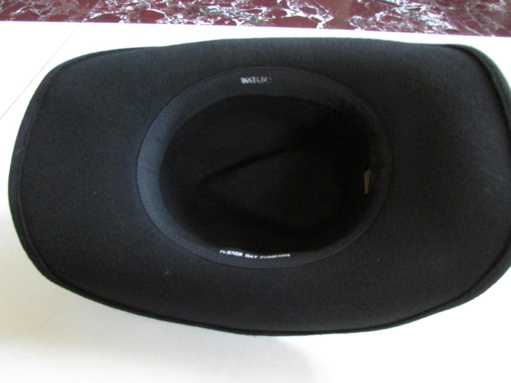 Inner view of a wide brim cowboy hat, showcasing its black wool fabric and smooth crown design.