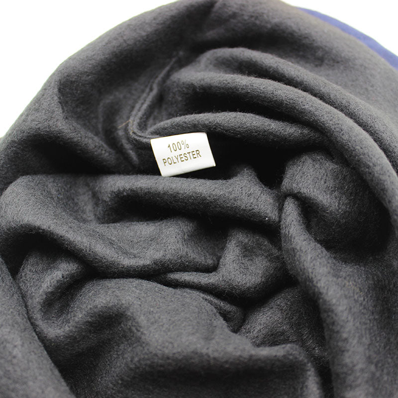 Close-up of the label showing 100% polyester fabric in a soft black knitted hat.
