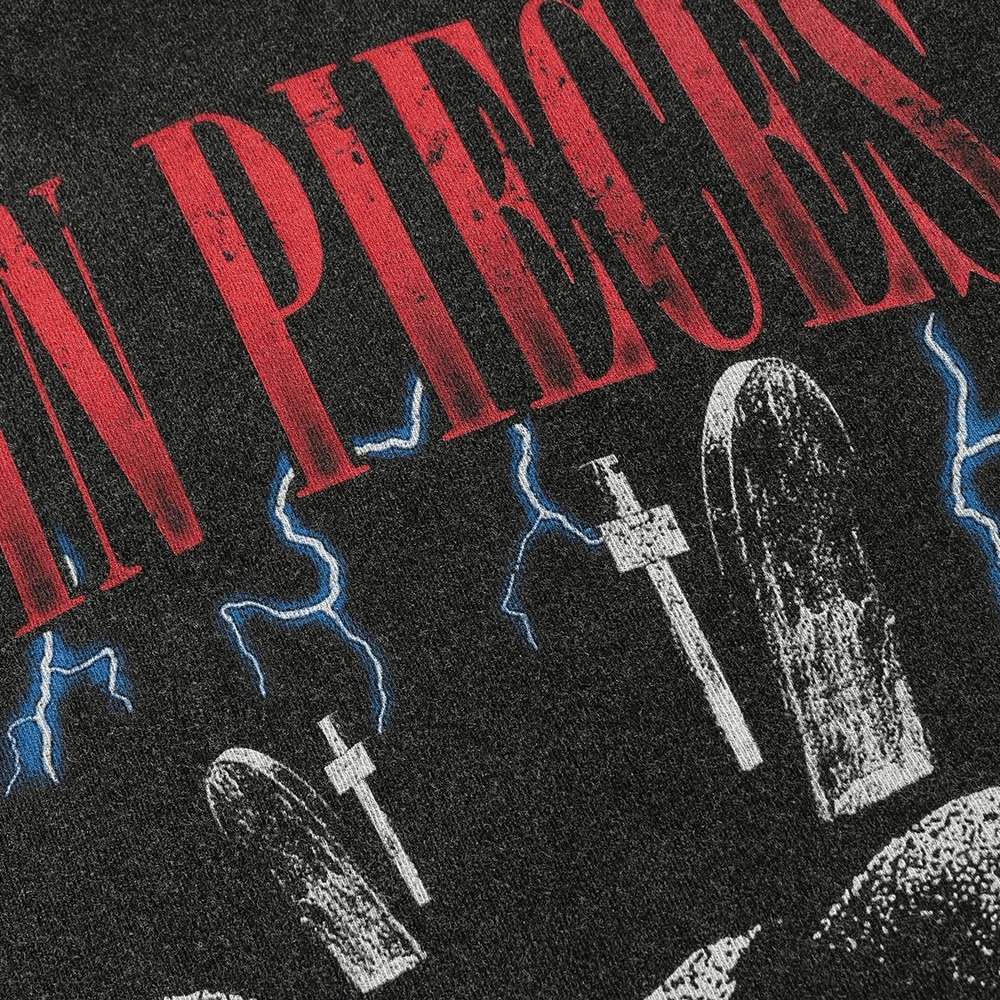 Close-up of a rock style t-shirt featuring a Letter Skull print with tombstones and lightning design.