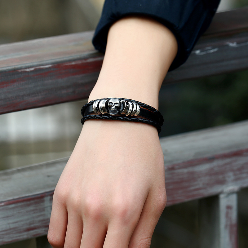 Stylish black leather rock style bracelet with silver skull, perfect for men and women as a trendy accessory.