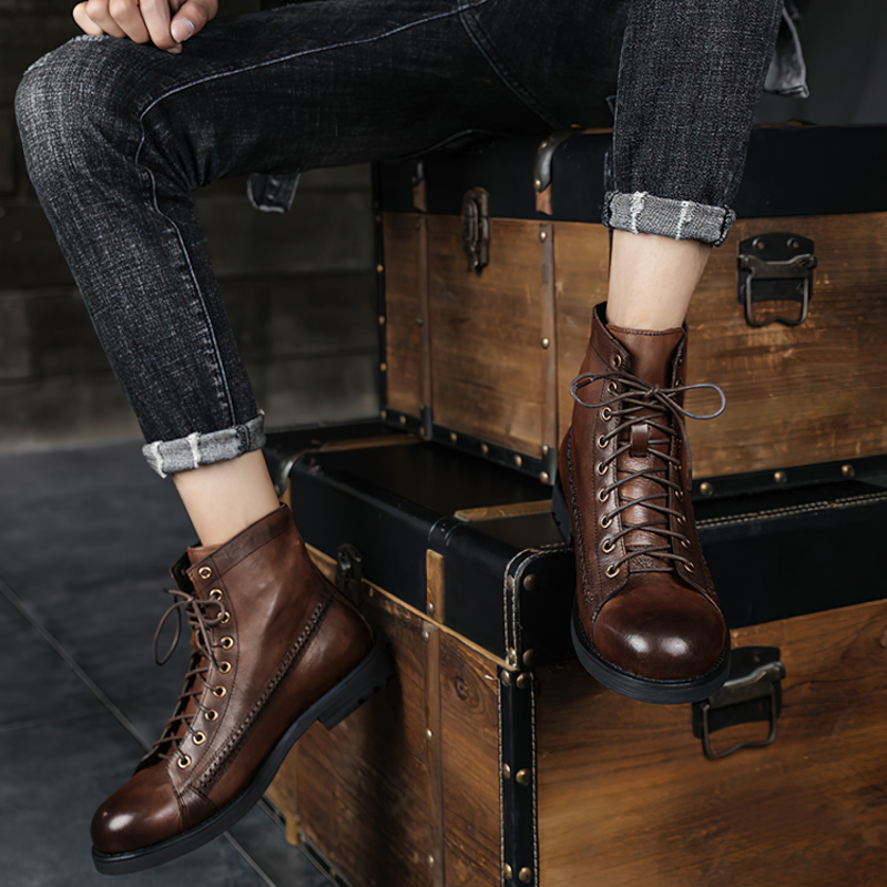 Men's brown PU leather lace-up ankle boots paired with rolled-up jeans, resting on vintage wooden boxes.