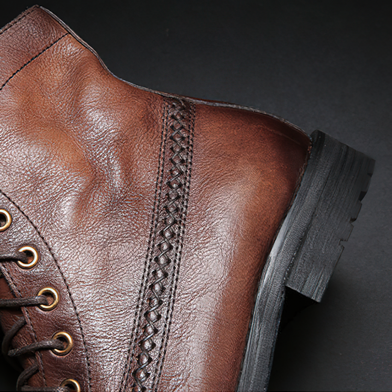 Close-up of stylish brown PU leather men's lace-up boots with braided detailing and sturdy sole.