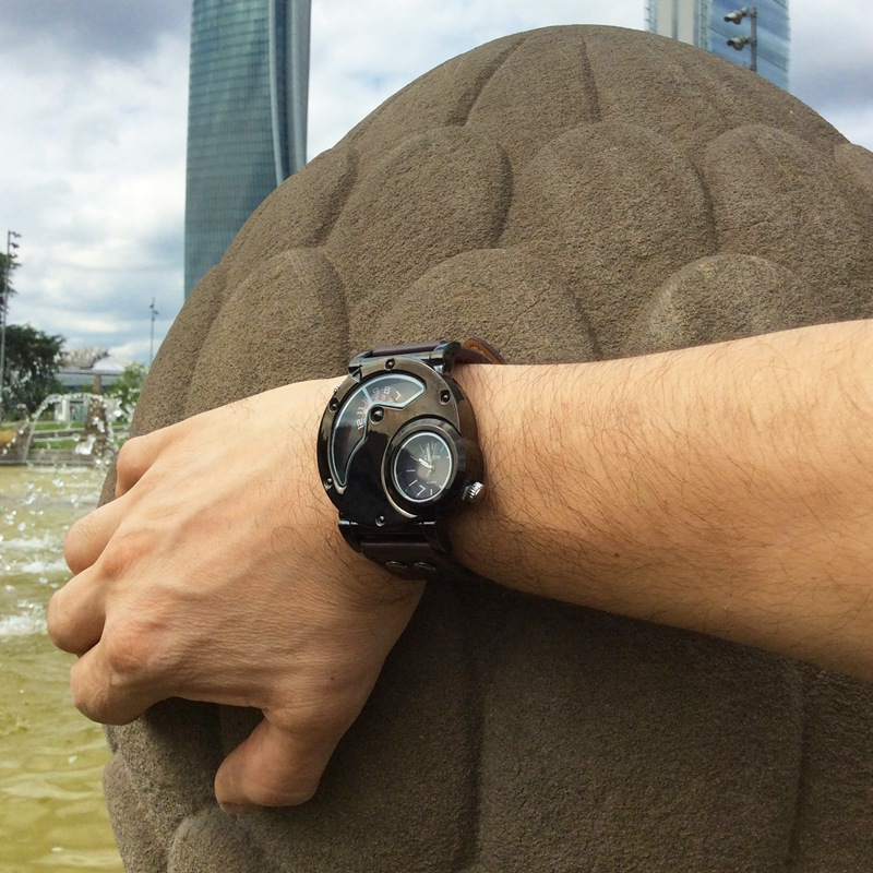 Man wearing a Rock Style Quartz Dual PU Leather Watch near a fountain, showcasing a modern and stylish look.