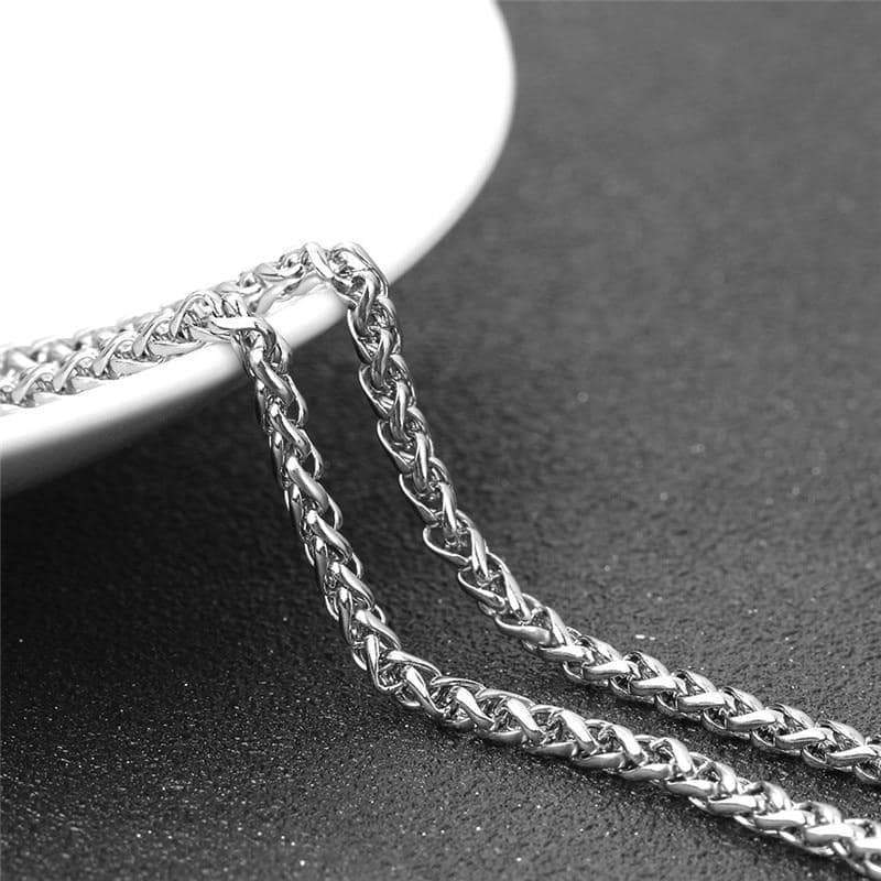 Close-up of a stainless steel chain necklace showcasing intricate links and shiny finish on a sleek background.
