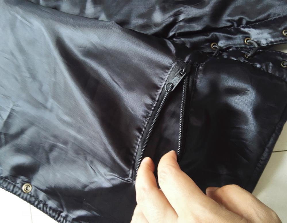 Close-up of a man's biker vest interior showing zipper pocket and a hand for style detail.
