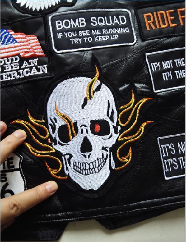 Close-up of embroidered skull patch with flames on a genuine leather biker vest, showcasing edgy rock style.