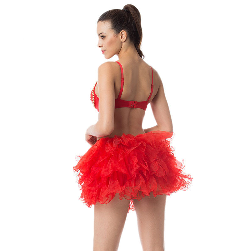 Model wearing a vibrant red push-up bra with a fluffy ruffled skirt from a playful angle.