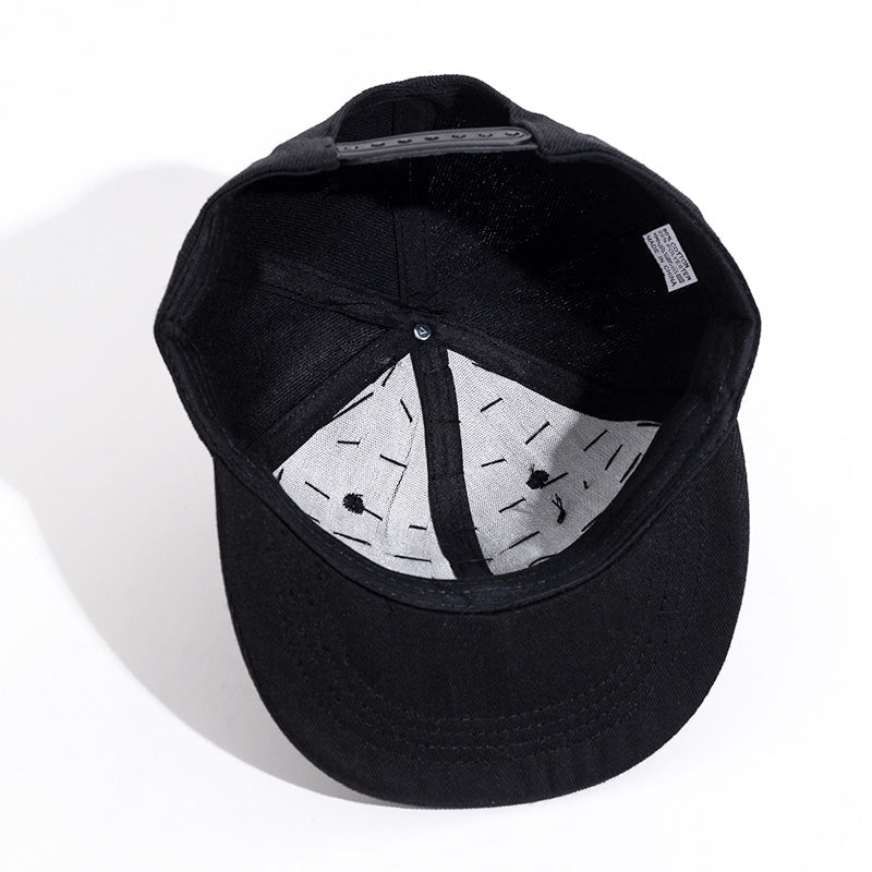 Inside view of a black snapback hat with a stylish lining and ventilation holes, perfect for rock style outfits.