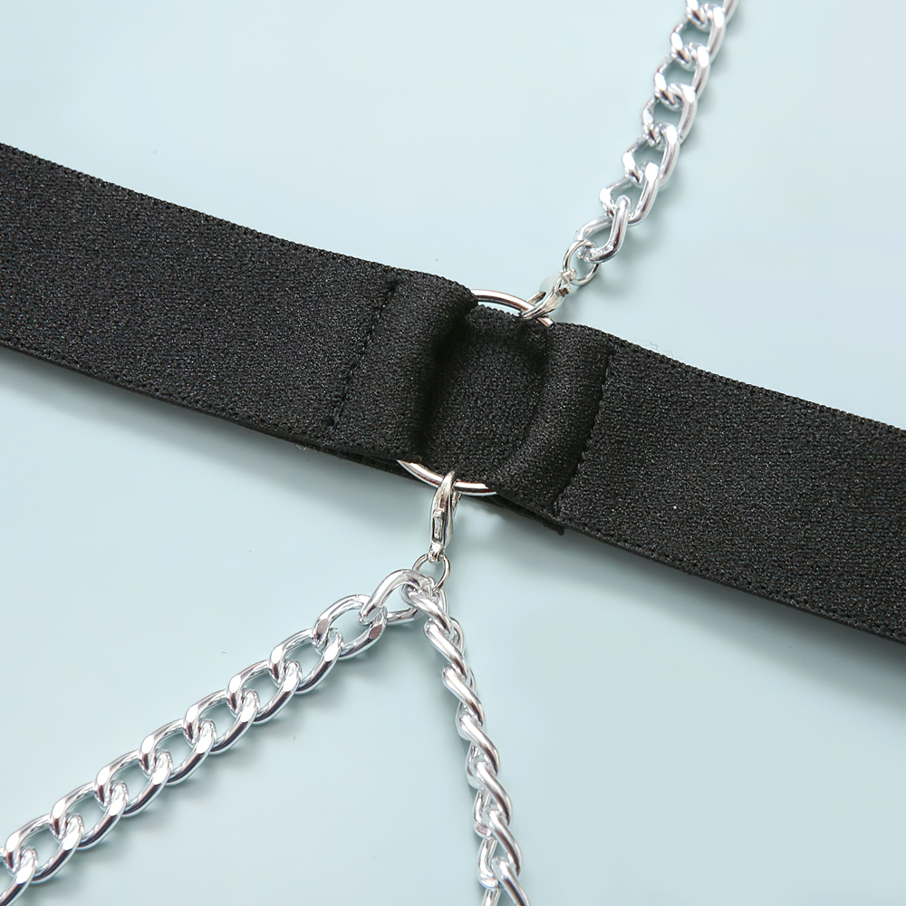 Close-up of black bodysuit strap with silver chain detail, showcasing stylish rock fashion design.