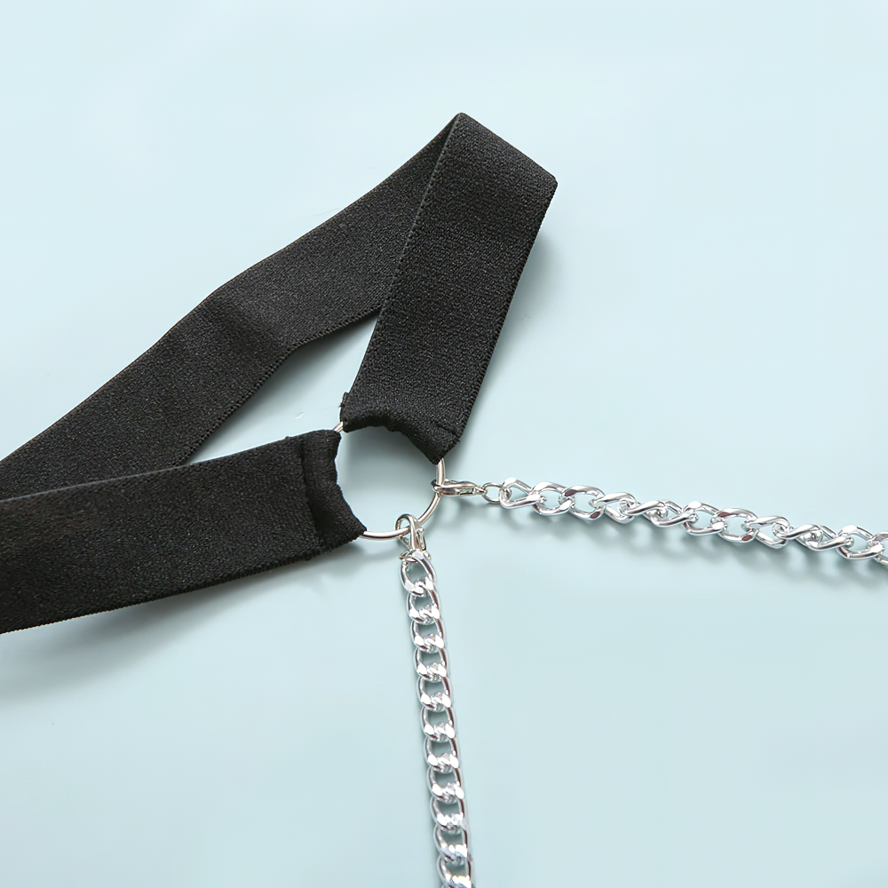 Close-up of a black strap and silver chain detail on a women's rock style bodysuit, showcasing trendy fashion elements.