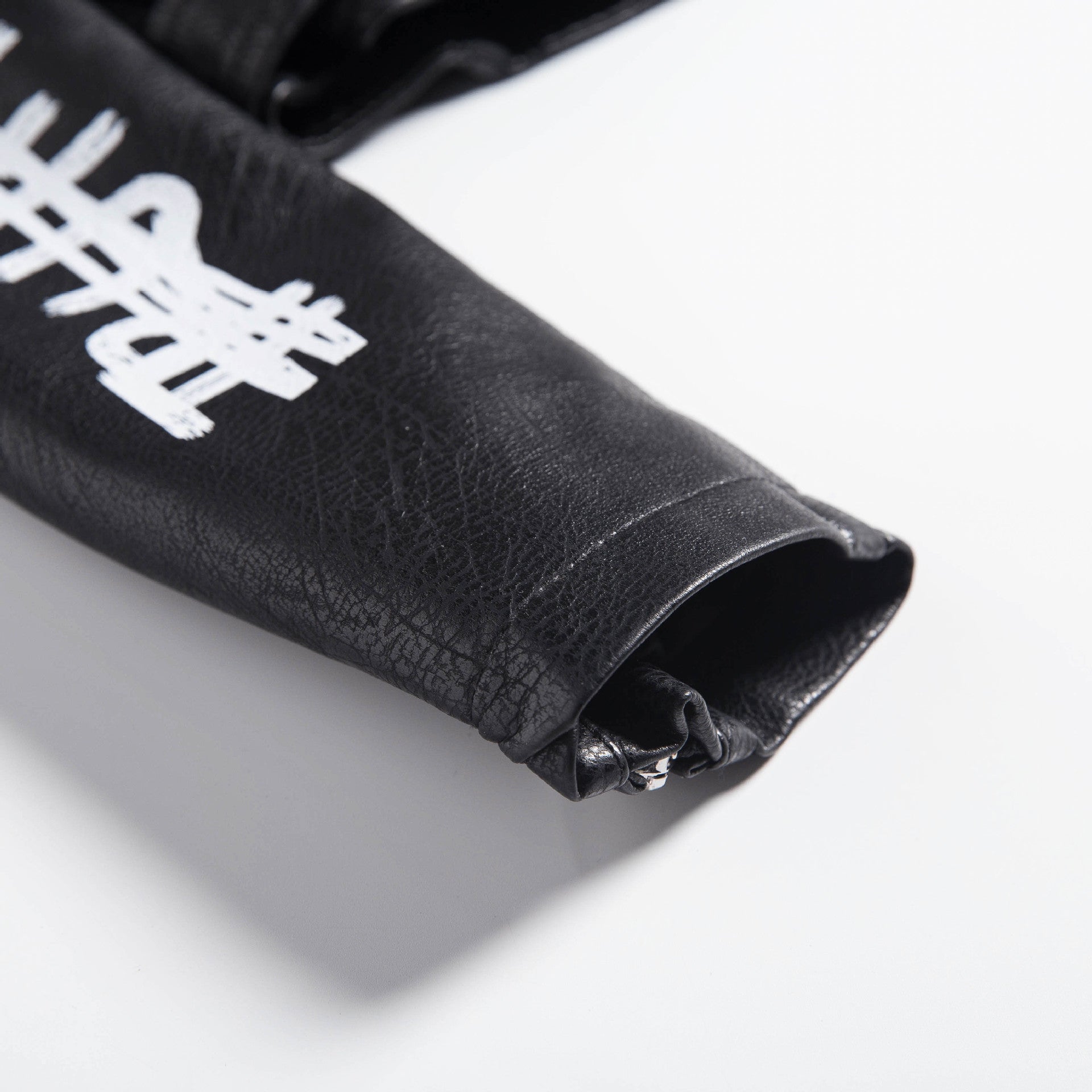 Close-up of a women's faux leather motorcycle jacket sleeve with 3D print details and studded design.