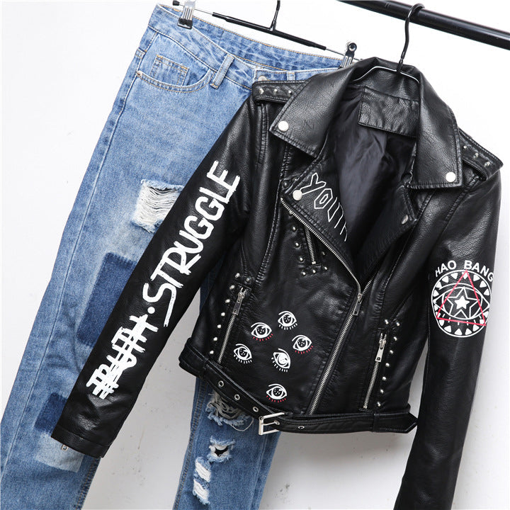 Faux leather motorcycle jacket with unique 3D print and studs, paired with distressed jeans, perfect for a rocker style.