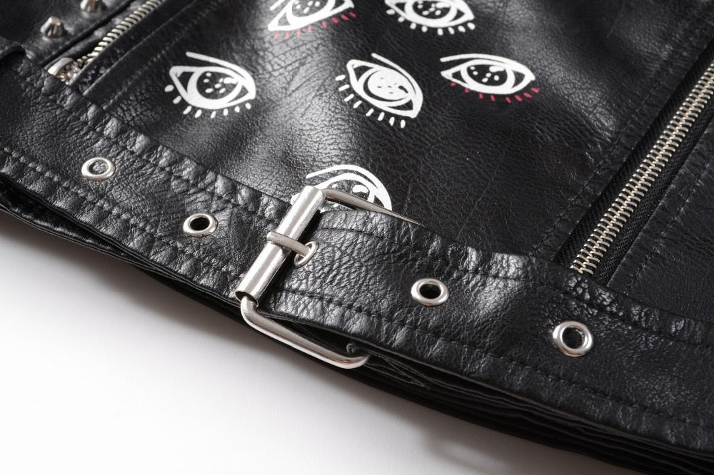 Close-up of a women's faux leather motorcycle jacket featuring unique eye prints and stylish zippers for a rocker vibe.