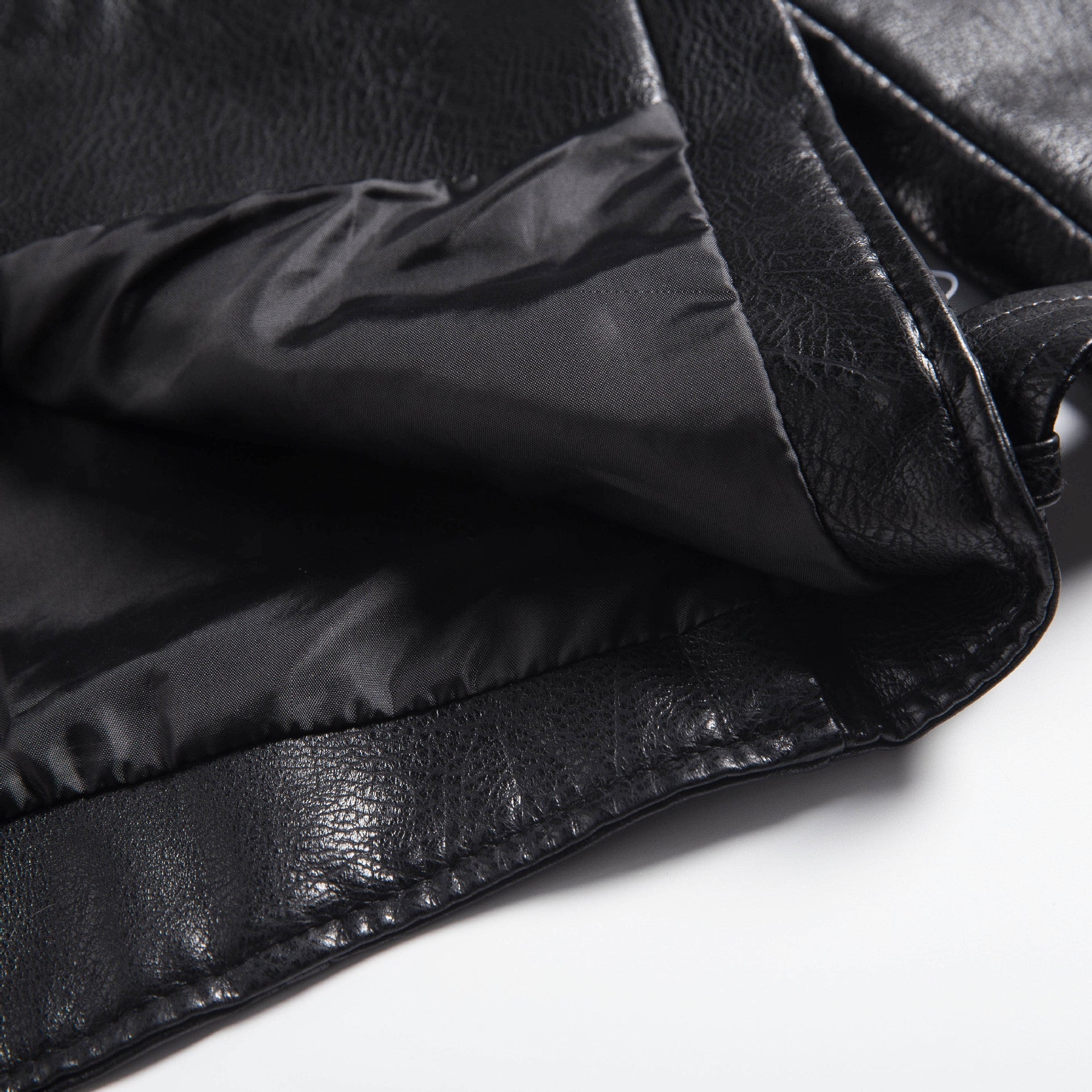 Close-up of a soft faux leather motorcycle jacket's interior showing its sleek lining and intricate design details.