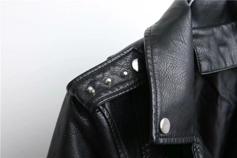 Close-up of a women's faux leather motorcycle jacket with studs and zippers, perfect for a rocker girl style.