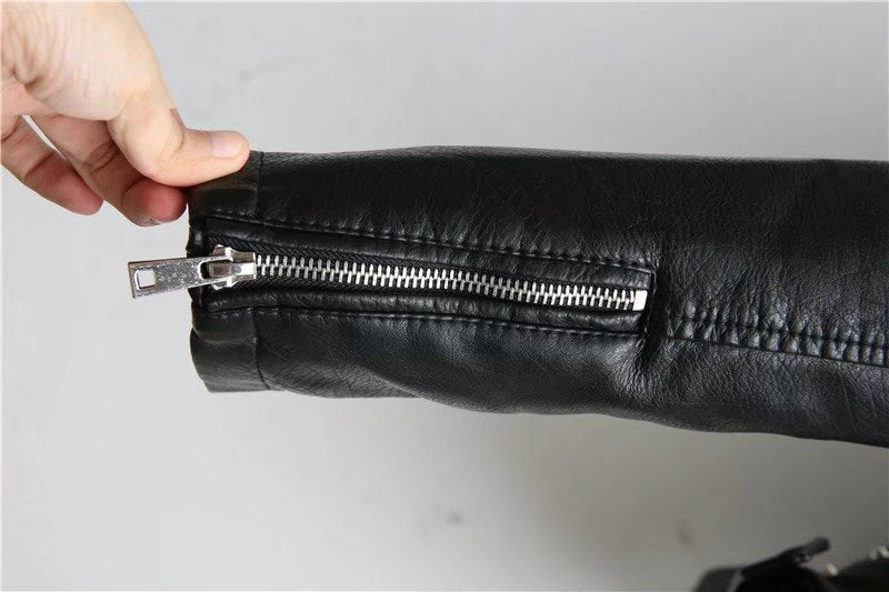 Close-up of a black faux leather jacket sleeve with a stylish silver zipper detail.