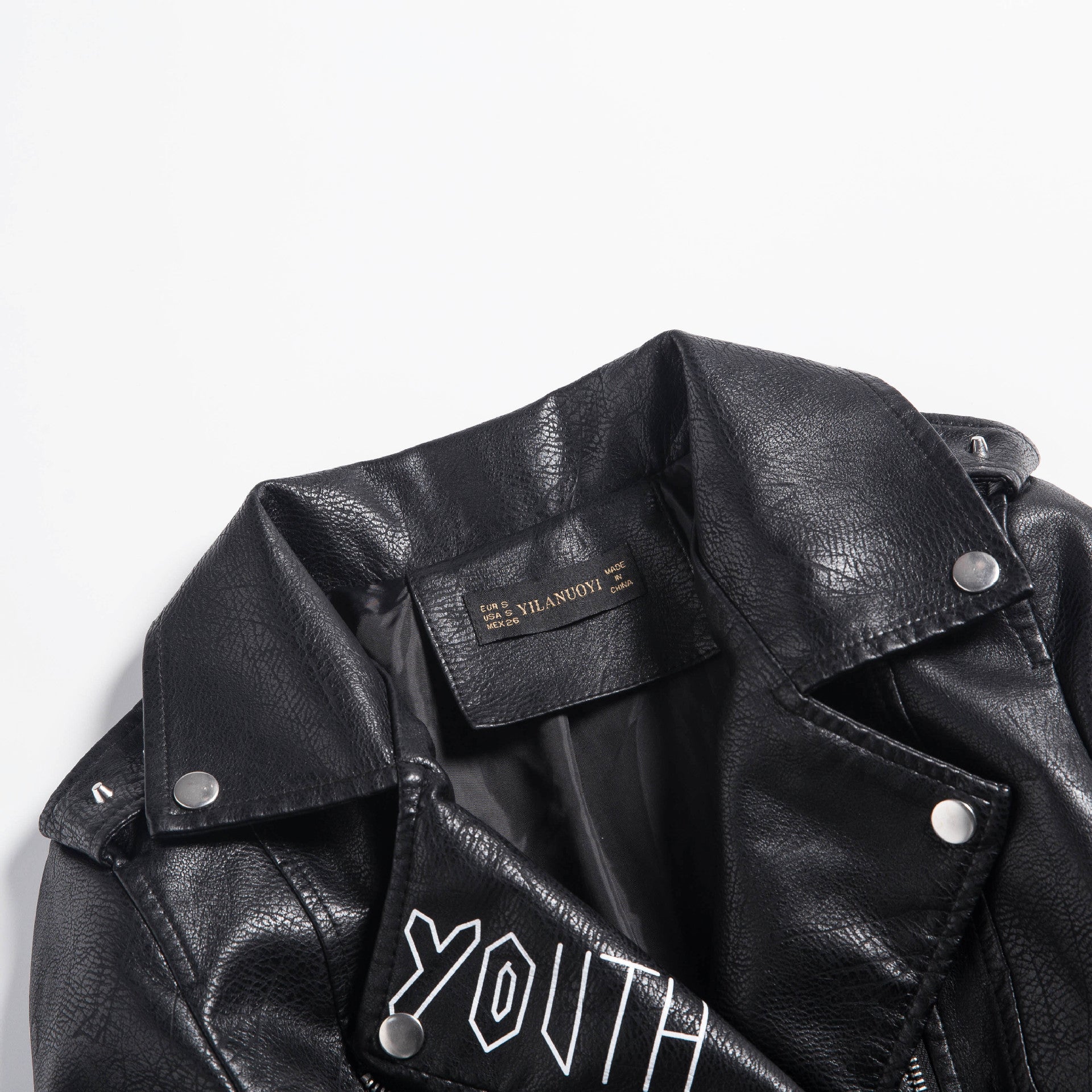 Close-up of a black faux leather motorcycle jacket with a youth design, showcasing its stylish details.