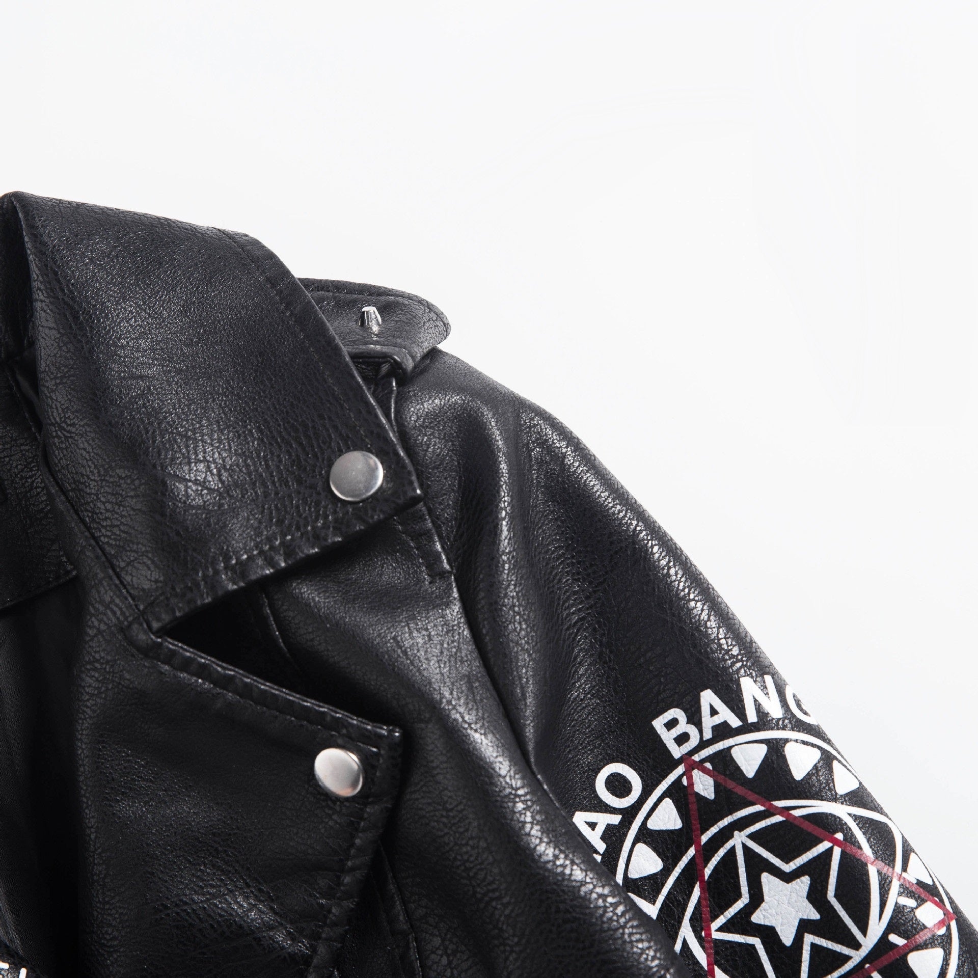 Close-up of a women's faux leather motorcycle jacket featuring studs and a unique 3D print design.