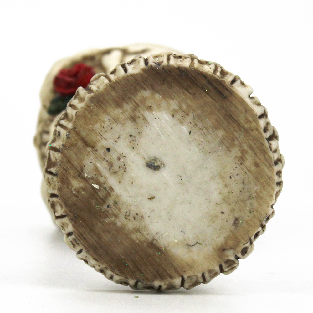 Bottom view of a gothic wine glass with rose and skull design, showcasing detailed texture and craftsmanship.