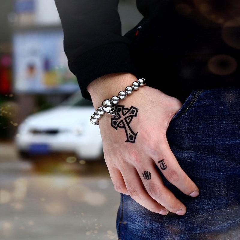 Round Bead Skull Biker Bracelet on hand with tattoos, showcasing trendy stainless steel rock accessories.