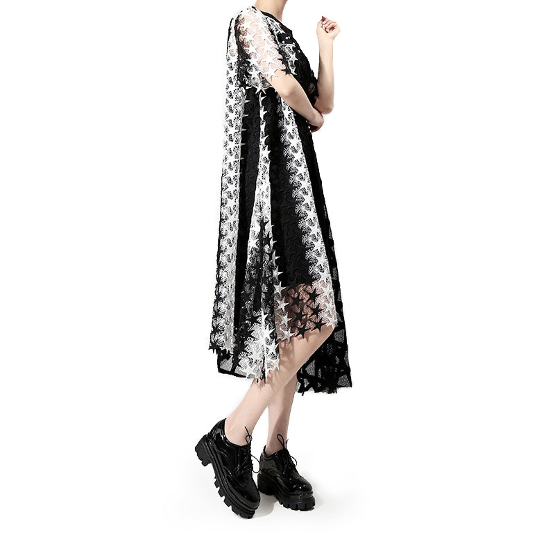 Model wearing a black and white irregular loose gothic dress with star patterns and short sleeves.