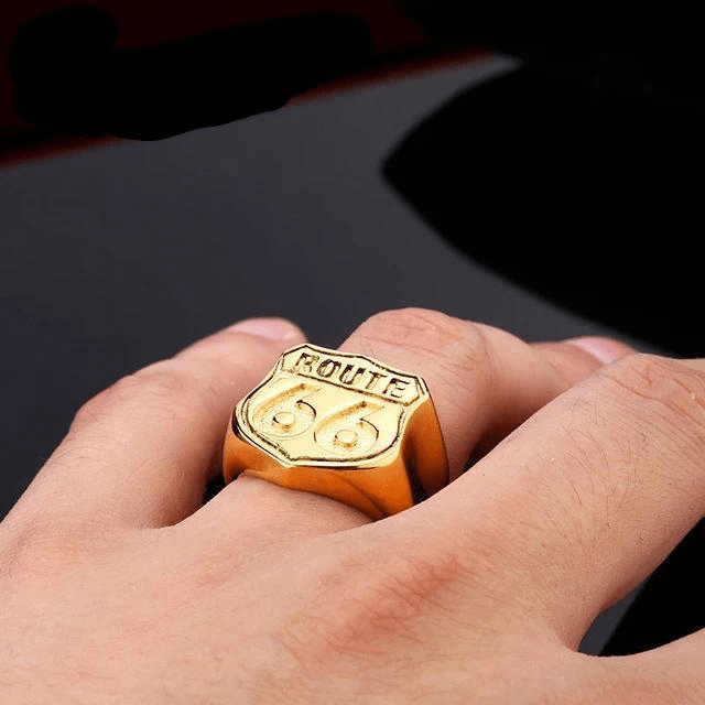 Golden Route 66 ring on a finger, showcasing vintage biker jewelry style and adventurous spirit.