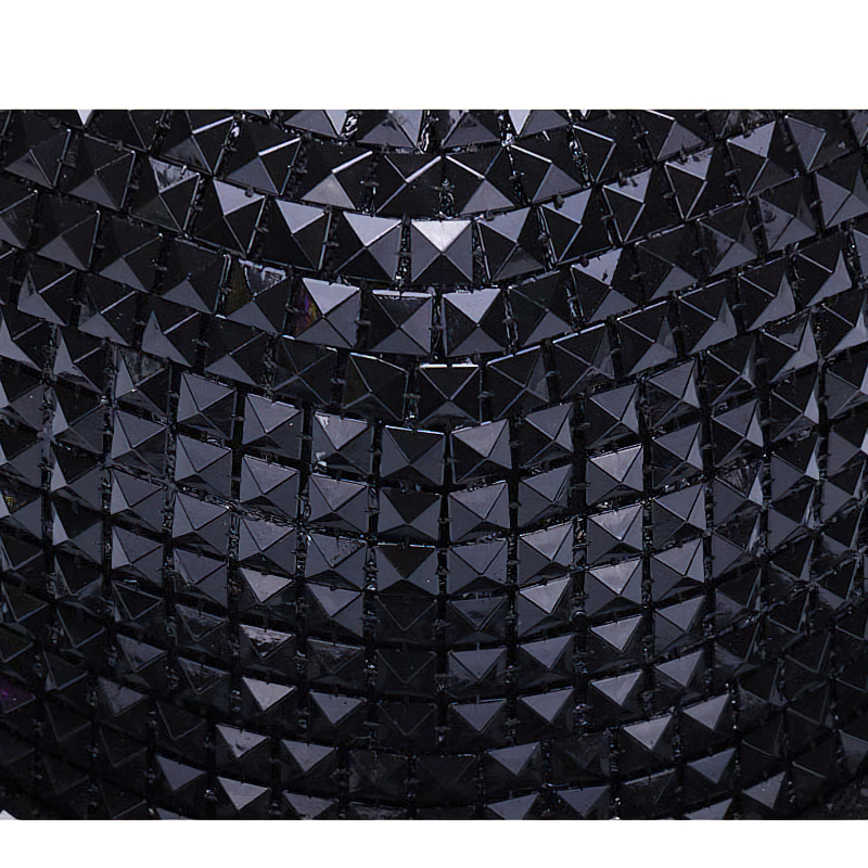 Close-up of black sequined fabric with pyramid shapes, perfect for a stylish punk rock baseball cap.