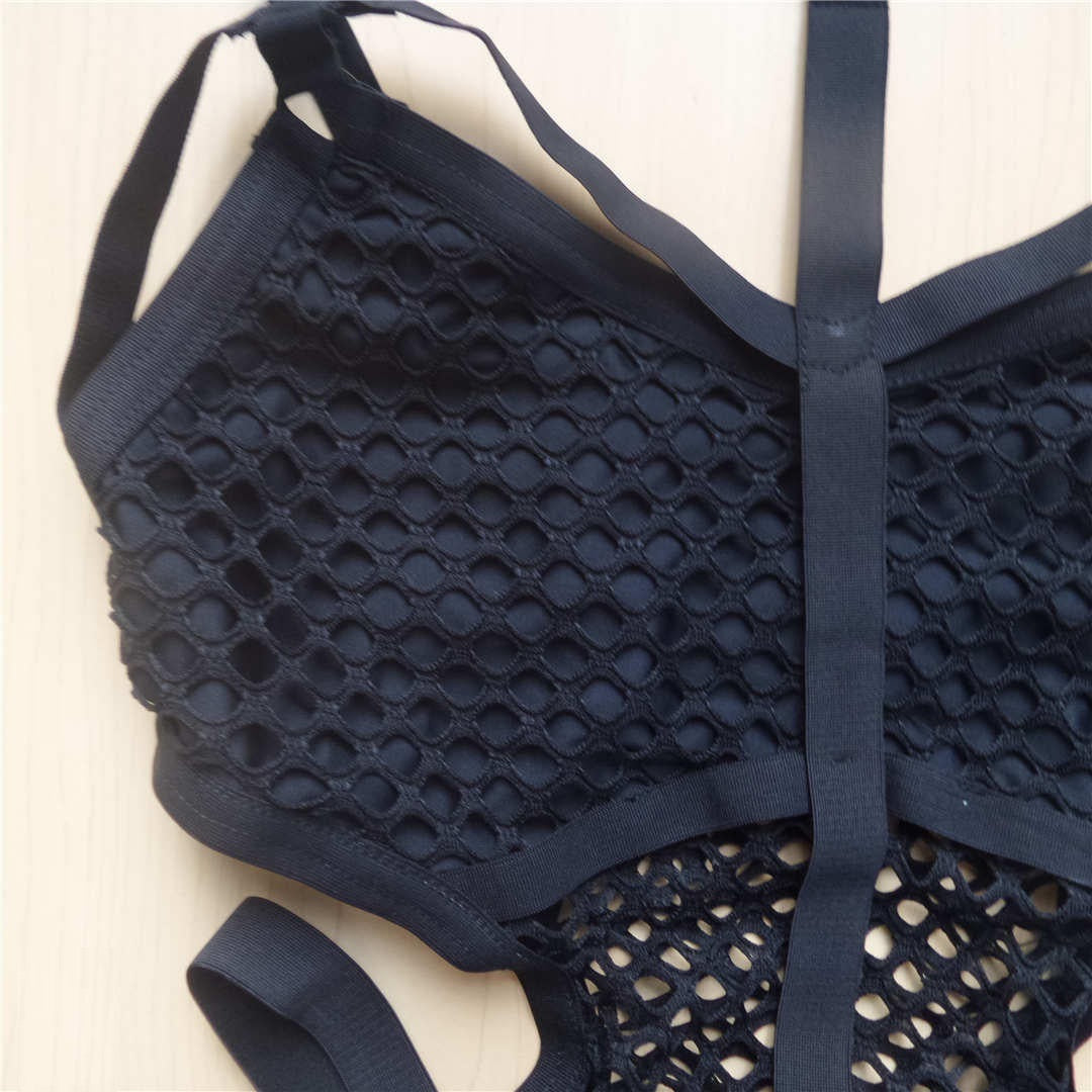 Close-up of sexy black net mesh women's one-piece swimsuit showing intricate mesh design and adjustable straps.