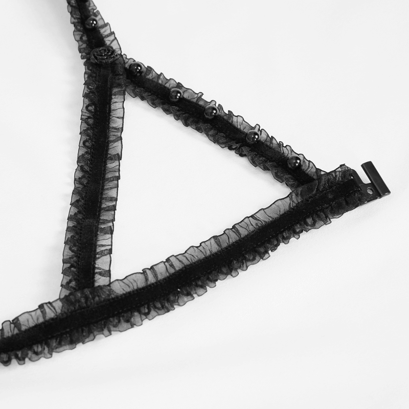 Detail of black lace lingerie set with ruffled edges and decorative beads, showcasing gothic elegance.