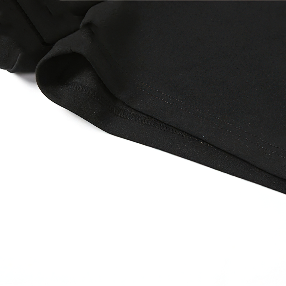 Close-up of the smooth hem of a stylish black women's asymmetrical mini dress fabric.