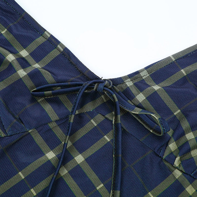 Close-up of the navy plaid design featuring a sexy bow lace-up detail on the mini dress.
