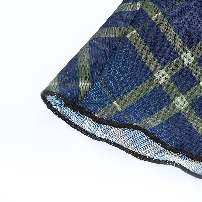 Close-up of the hem of a blue and green plaid mini dress with lace detailing, showcasing its stylish grunge design.