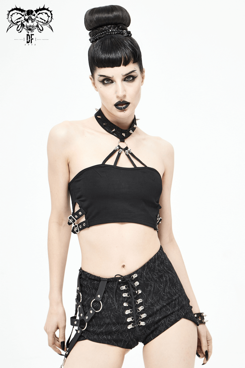 Gothic style black crop top with buckles and spikes, showcasing bold female fashion and edgy trends.