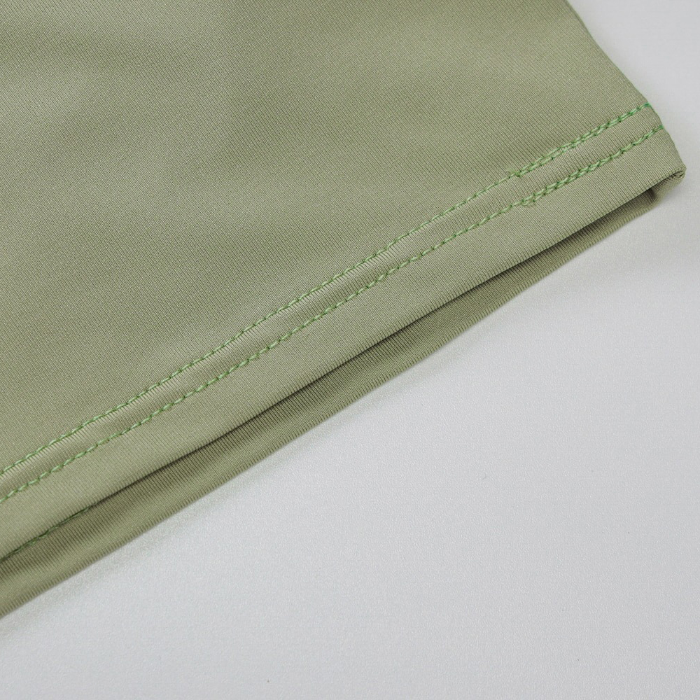 Close-up of the stylish double ring crop top fabric with green stitching detail, showcasing alternative fashion design.