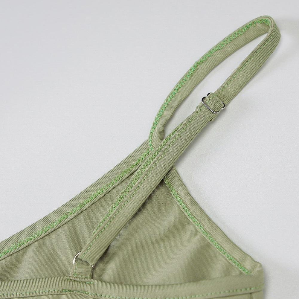 Close-up of sexy double ring straps on a green women's crop top with stylish stitching details.