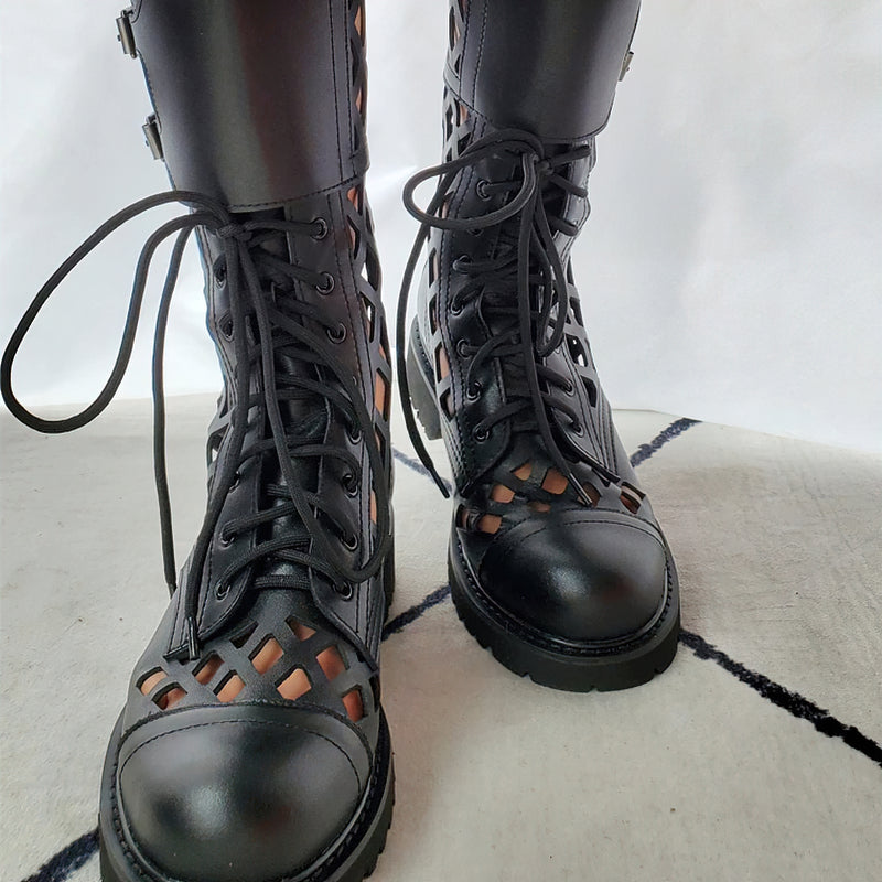 Stylish black leather lace-up boots with metal details and cutout design for a trendy goth look.