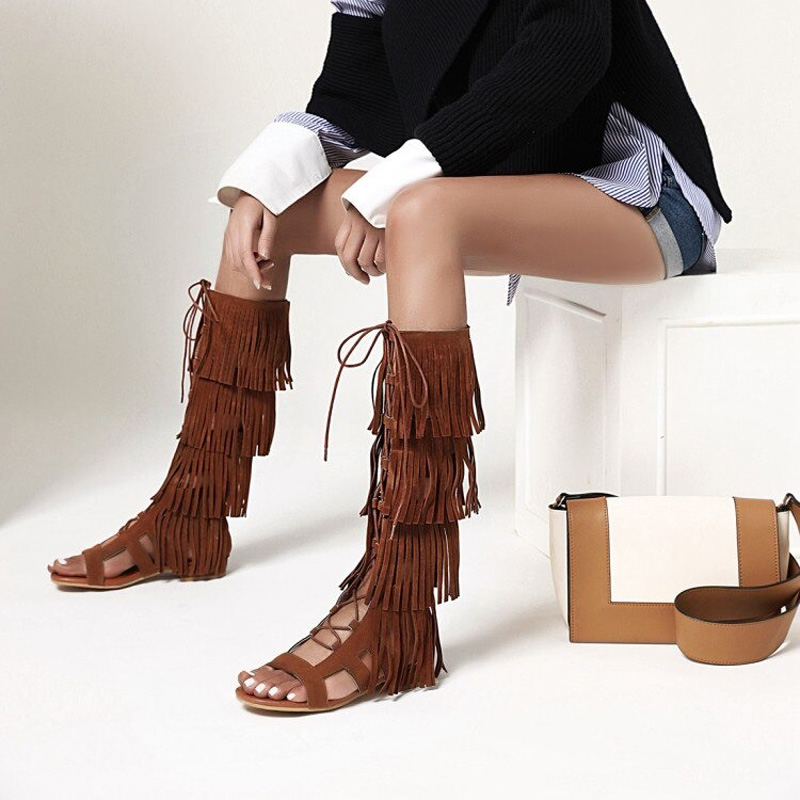 Fashionable brown gladiator sandals with fringe and ankle ties, perfect for stylish summer looks and festivals.