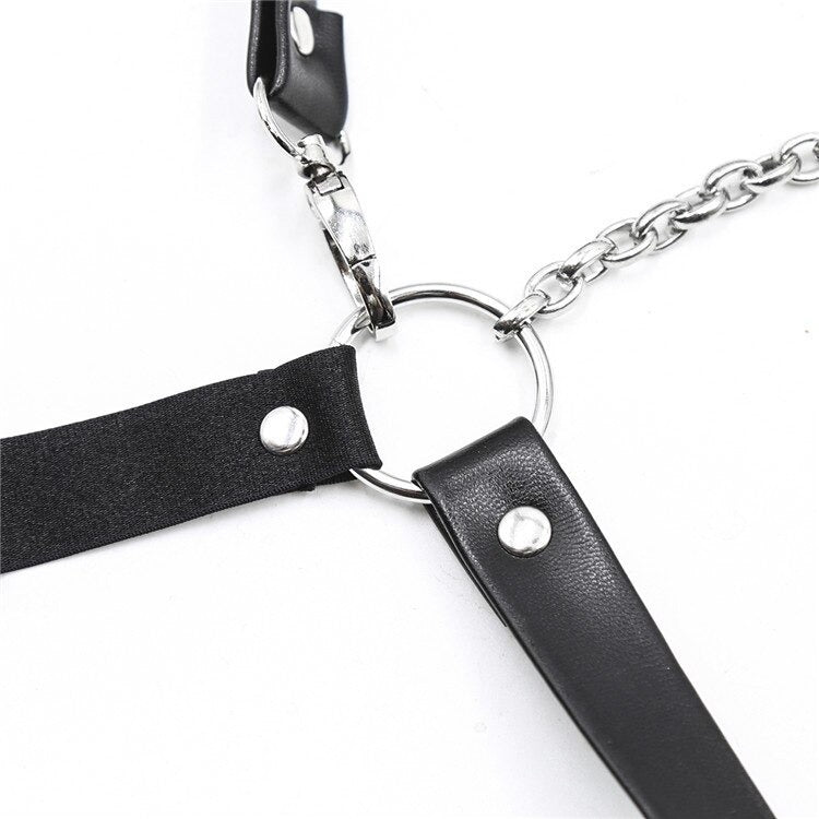Close-up of a sexy gothic body harness featuring synthetic leather straps and a silver chain, perfect for edgy fashion.