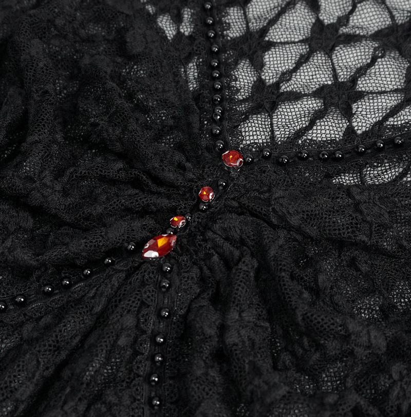 Close-up of black lace fabric top with red crystals, showcasing gothic style details.