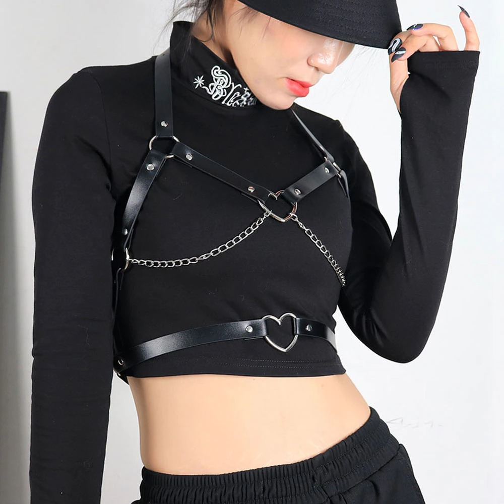Model wearing a sexy gothic suspender belt bra with chains and heart-shaped connector, styled in black.