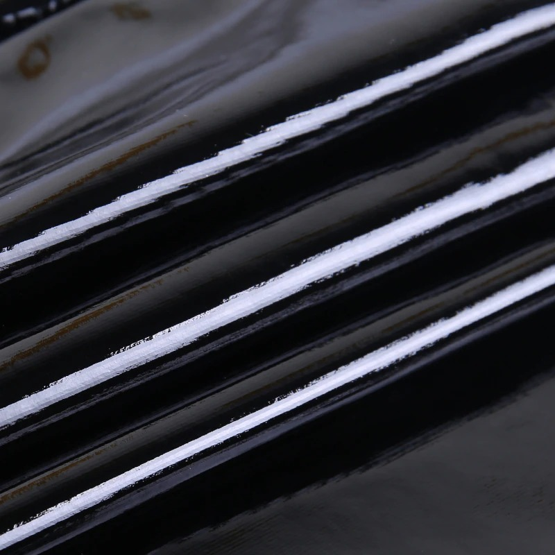 Close-up of glossy black latex fabric showcasing sleek texture for a sexy gothic mini dress.