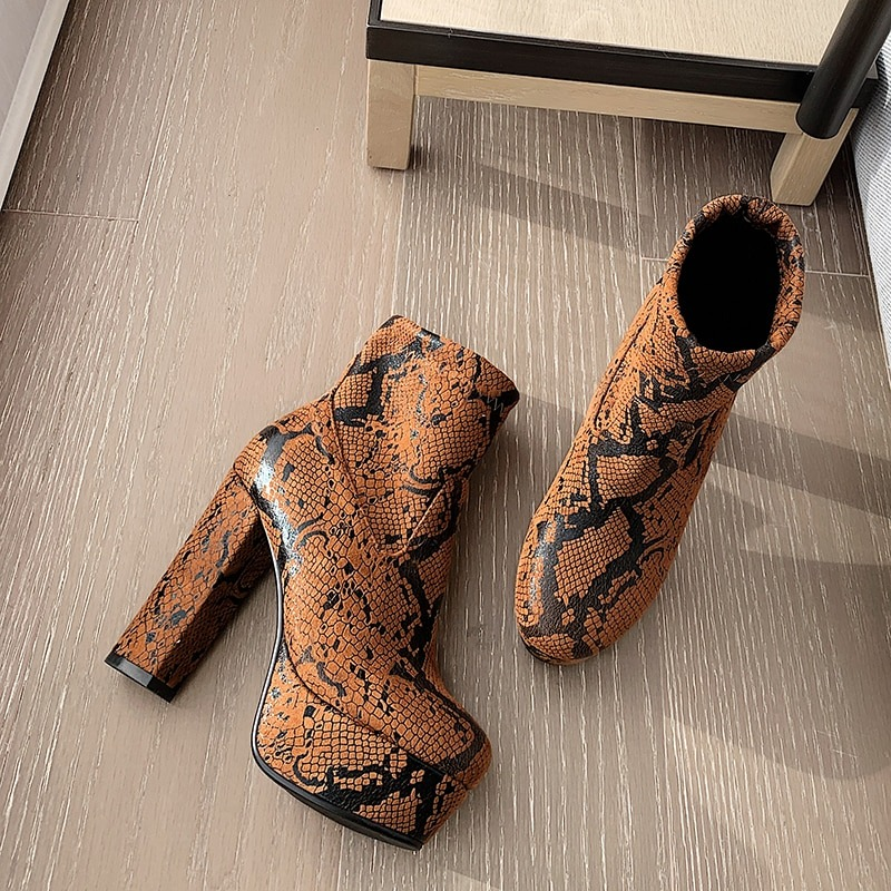 Stylish women's ankle boots in orange snakeskin print with chunky high heels, perfect for trendy fashion looks.