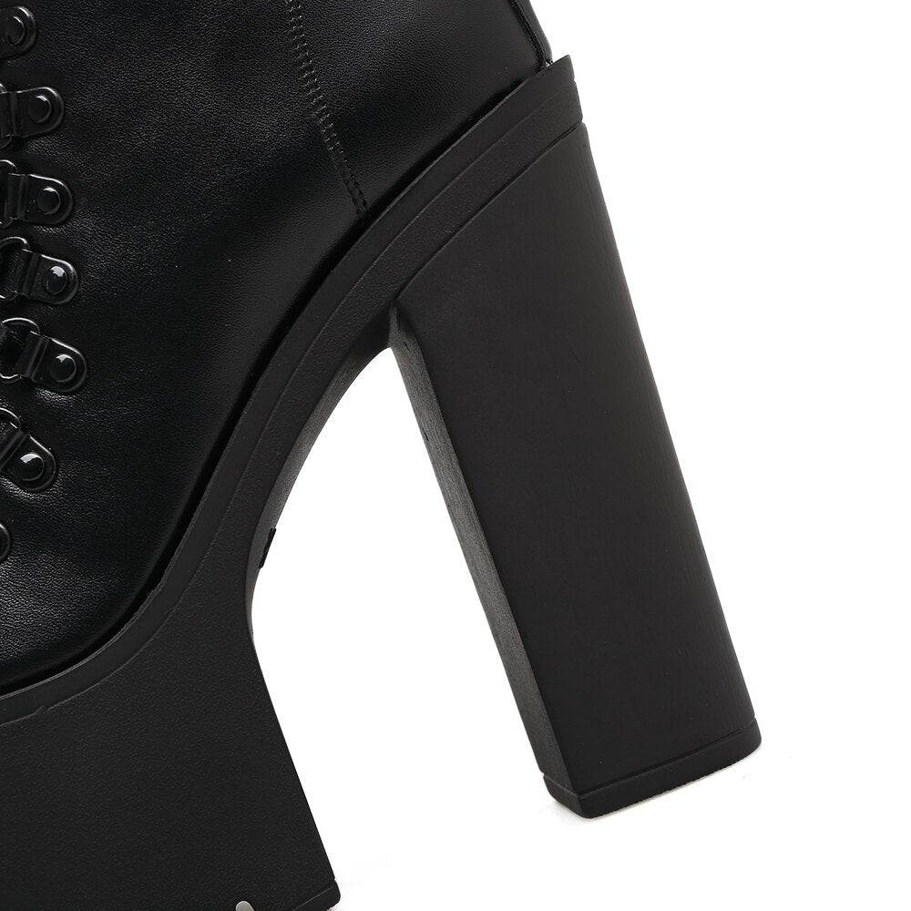 Close-up of a stylish black platform ankle boot with a chunky square heel and laced detail, perfect for rocker outfits.