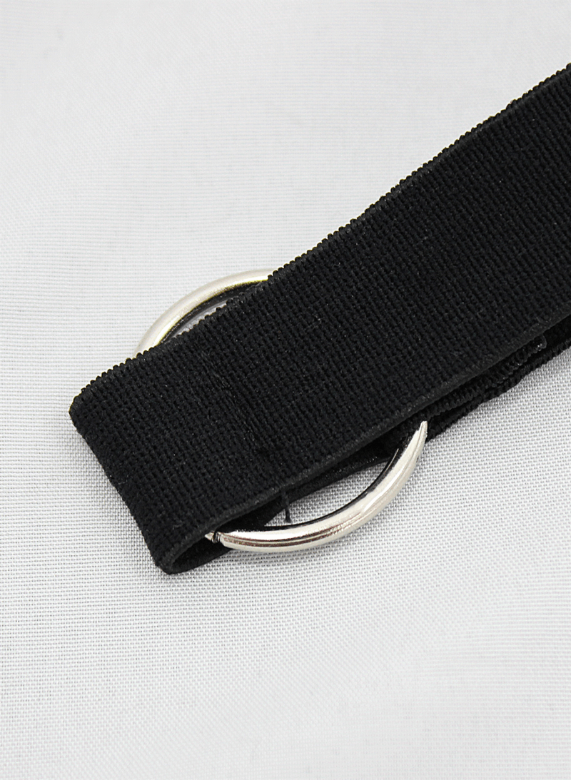 Close-up of a black elastic strap with a metal ring, perfect for gothic fashion accessories.