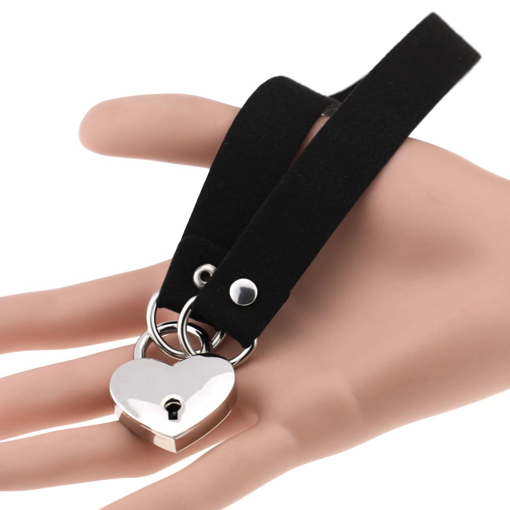 Black suede heart lock choker collar with silver key pendant on a mannequin hand, perfect for gothic alternative fashion.