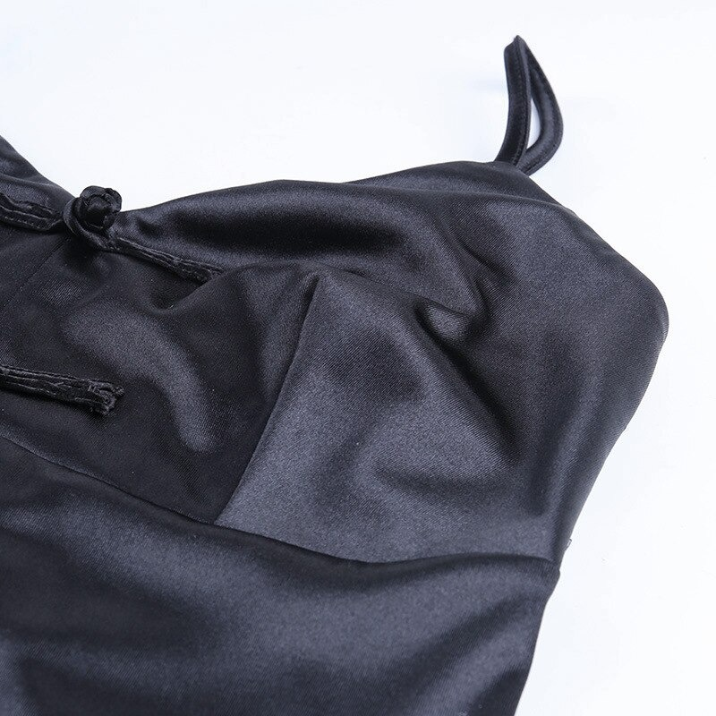 Close-up of a black gothic v-neck dress with straps and decorative bows, perfect for stylish outfits.
